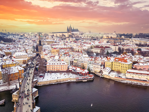 Beautiful aerial sunset view of the snow covered old town of Prague with Charles Bridge and castle, Czech Republic