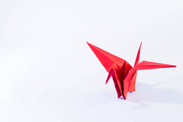 istock Red origami crane on white background 1453446382