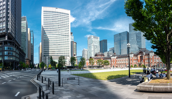 Tokyo, Japan - 09.14.2022: Tokyo Station and its surroundings. Historical Tokyo station building and modern skyscrapers around it on a beautiful day of summer. Center of Japanese capital