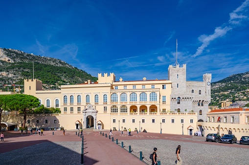 Monaco, Monaco – October 16, 2022: The Prince's Palace of Monaco front view in a blue morning people walking and the guard next to the main door