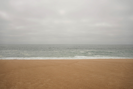 Calm seaside with no waves on a cloudy day