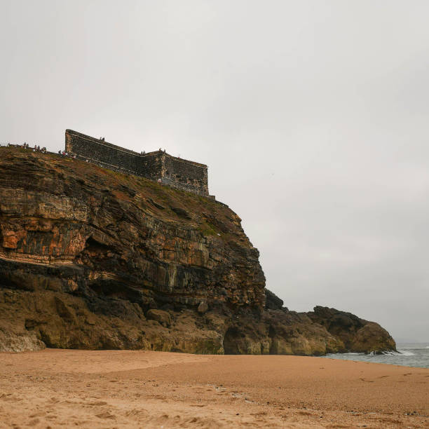 istock Coastal rock at a sandy seaside on a dark day 1453447179
