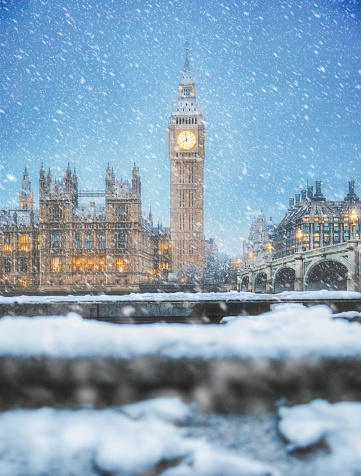 Snow falling on a snowy winter day at Westminster Bridge during a snowstorm with Big Ben and the Houses of Parliament in the background in London, England, United Kingdom
