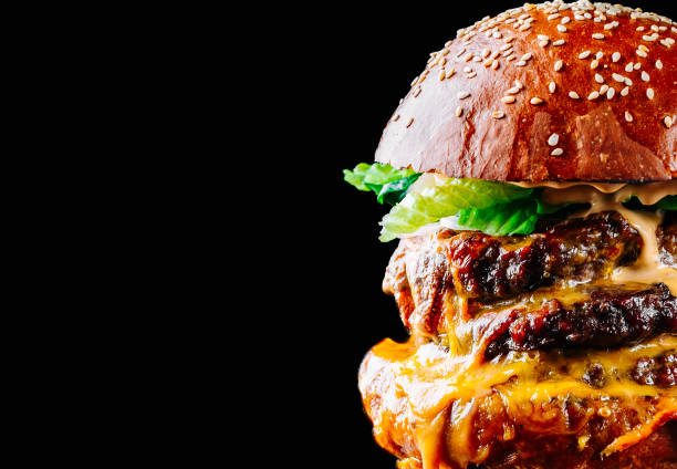 istock triple beef burger with meat, vegetables and cheese on black background 1453450319