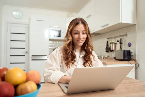 istock Pleased young woman working on portable computer 1453453819