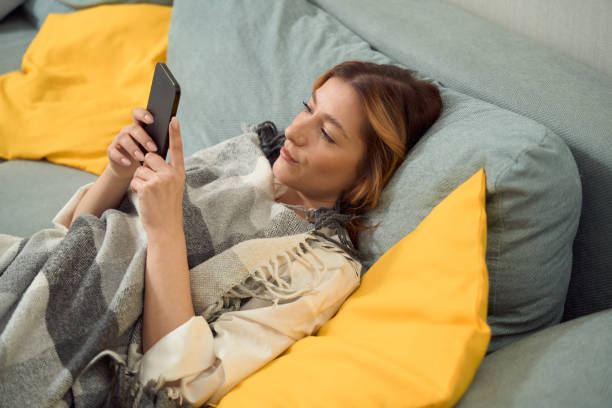 istock Focused female sending text message on her mobile phone 1453454026
