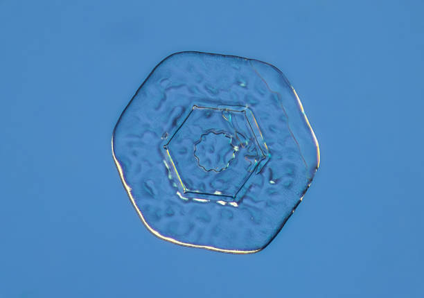 istock Snowflake on smooth gradient background. Macro photo of real snow crystal on glass surface. This is small snowflake crystal with unusual pattern 1453455991