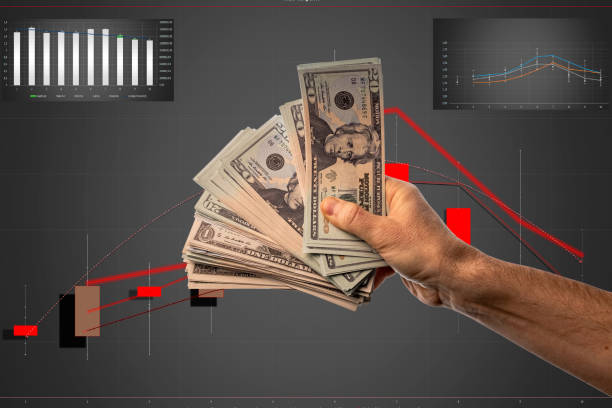 istock Man's hand holding a fan-shaped stack of dollars 1453458364