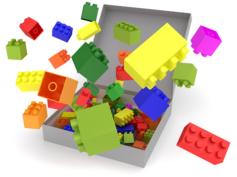 Cardboard box full of colorful toy bricks