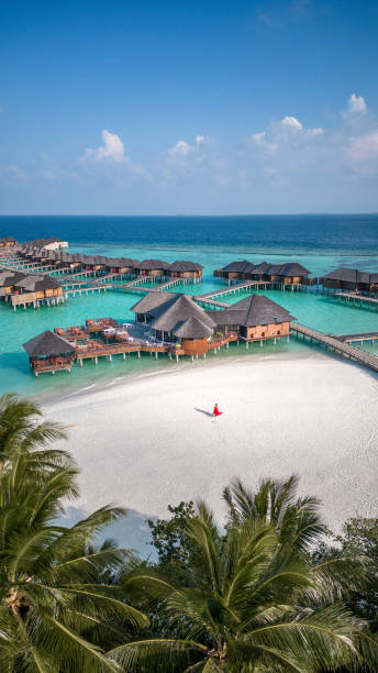 donna che cammina sulla spiaggia alla laguna dell'hotel delle maldive e alla spiaggia sul resort tropicale dell'isola - travel luxury aerial view beach foto e immagini stock