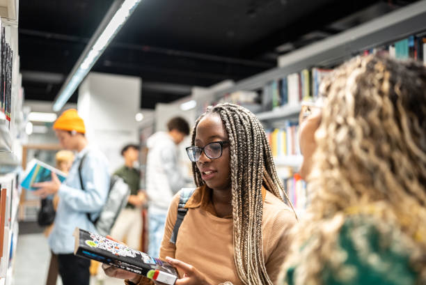 istock Young students women talking with her colleague at university library 1453464098