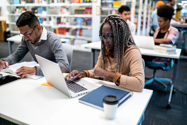 istock Young student woman studying using laptop at university library 1453465380