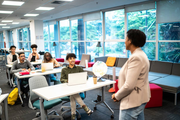 istock Mature teacher woman talking to students during class at university 1453465464