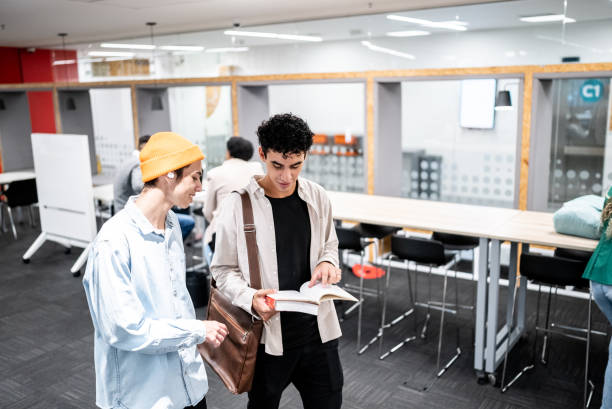 istock Friends talking and reading a book while walk at university 1453466547