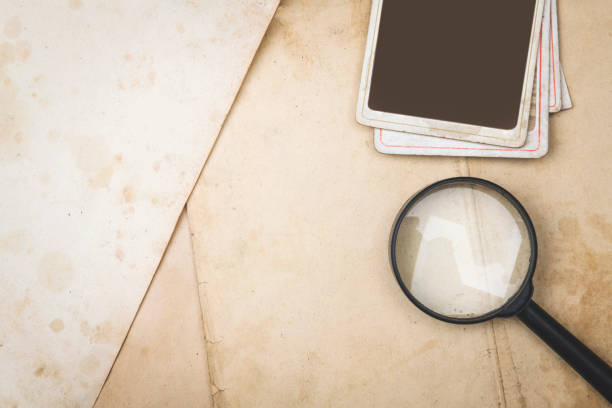Magnifying glass and photo frame on the old paper
