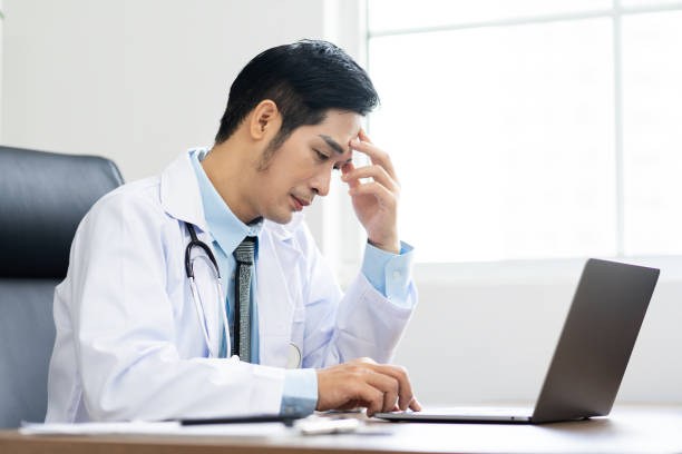 istock Asian male doctor portrait sitting at work 1453471588