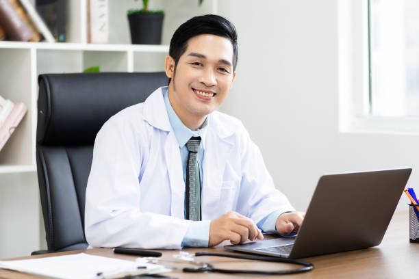 istock Asian male doctor portrait sitting at work 1453471589