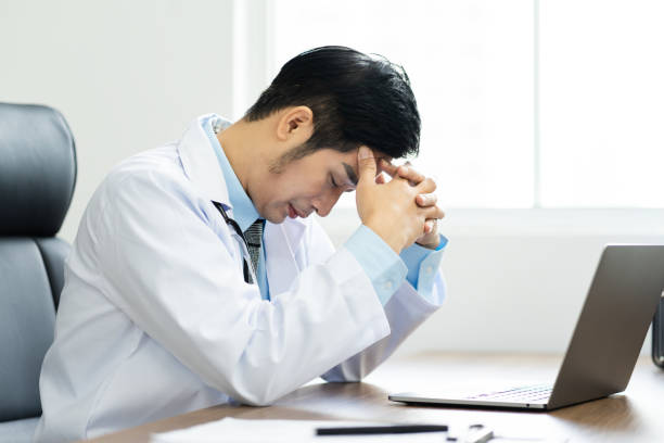 istock Asian male doctor portrait sitting at work 1453471631