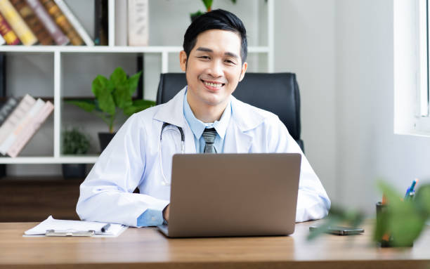 istock Asian male doctor portrait sitting at work 1453471650