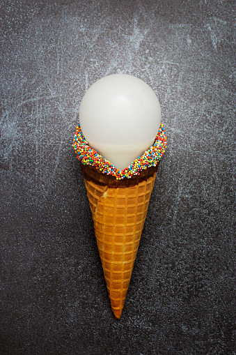 Energy saving led bulb in ice cream cone on grunge background