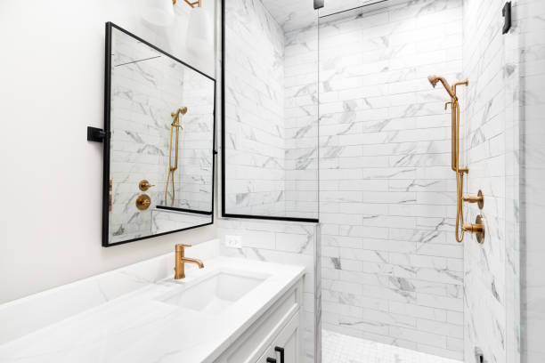 istock A white bathroom with marble subway tiles and gold faucets. 1453472782