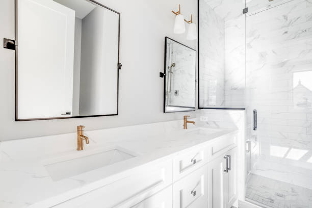 istock A white bathroom with gold faucets and marble subway tile shower. 1453472789