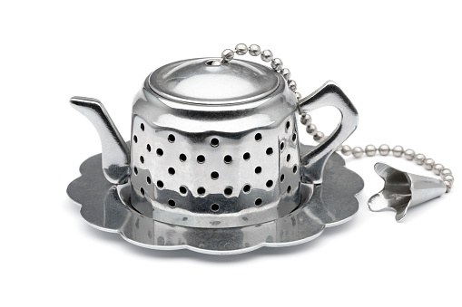 Tea strainer in the shape of a tea pot isolated on white background