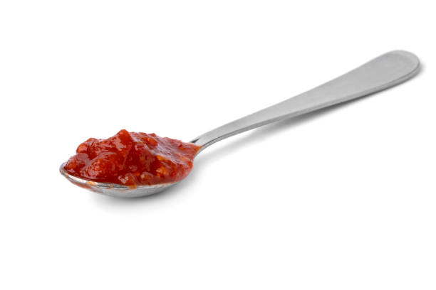 istock Metal spoon with red sambal, Indonesian chilli sauce, on white background 1453473555