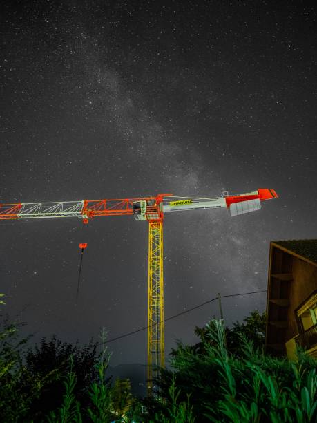 Annecy, France – August 03, 2021: A crane by Potain captured in Sevrier, France near Annecy with a beautiful mikly way in the background.