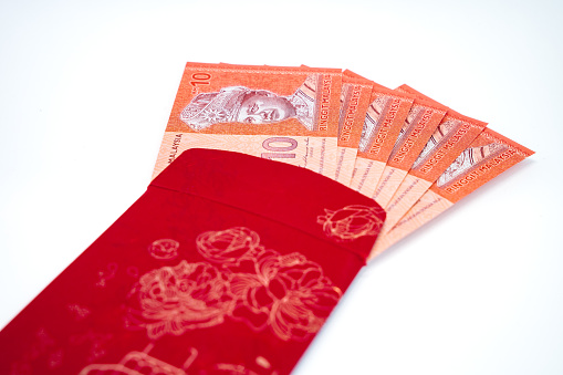 Chinese new year festival red envelope with Ringgit Malaysia note on white background. Festive season, celebration, auspicious, prosperity concept.