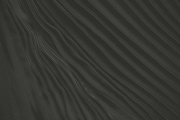 istock black wavy flowing fabric as background close up 1453492019