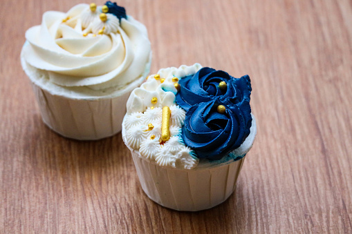 Luxurious and elegant cupcakes, with white cream and navy blue with gold sprinkles. It has a sweet and creamy taste.