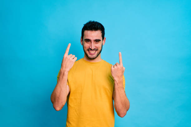 istock Happy man with red shirt pointing at empty space 1453494705