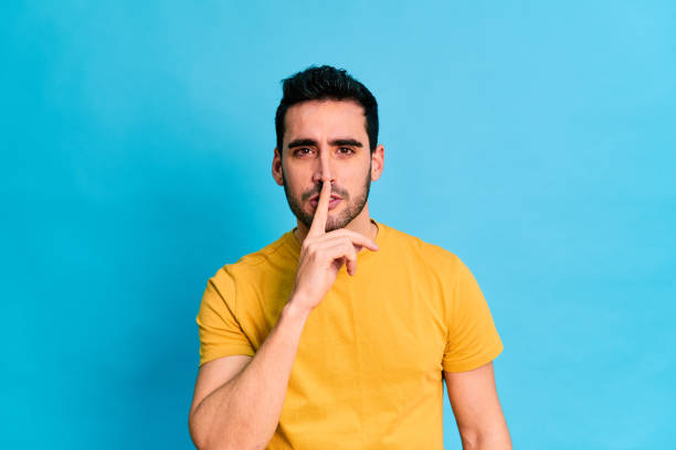 istock Shocked man doing a silence gesture and looking at camera 1453495359