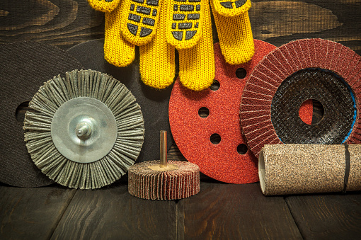 Set of abrasive tools and yellow work gloves on black vintage wooden boards wizard is used for grinding items
