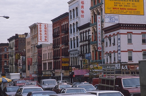 New York City (Chinatown?), NY, USA, 1984. Rush hour in a New York residential district. Also: shops, buildings and advertising signs.