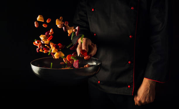 istock Cooking vegetables by chef hands on dark background copy space. Food concept. Vegetable menu for the hotel 1453499676