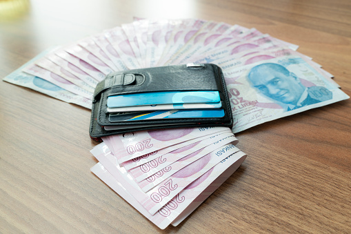 Turkish money banknotes and wallet. The wallet contains credit cards and money. Taken from a high angle with a full frame camera.