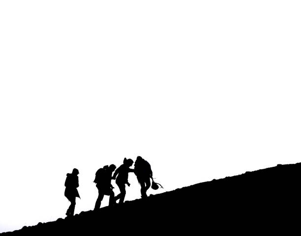 New Delhi, India - January 16, 2011: A group of small Indian school boys running down a footpath, smiling happily. They are wearing school uniforms, their teachers watching in the background. Black and white image with copy space. In India, children that have the privilege to attend school have to wear school uniforms,