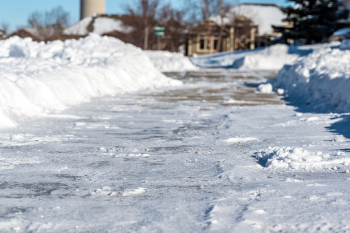Selective focus on cut bank of a snow blown sidewalk section with path continuing. . High quality photo