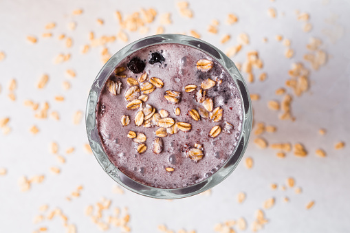 Blackberry and oat smoothie on white background.