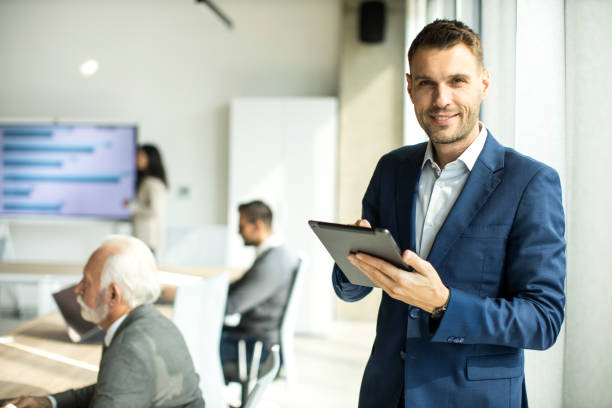 istock Confident young man businessman working inside modern office on a digital tablet 1453514569