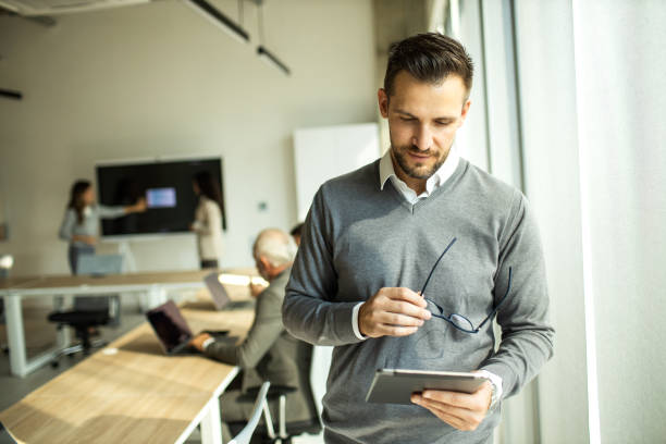 istock Confident young man businessman working inside modern office on a digital tablet 1453522863