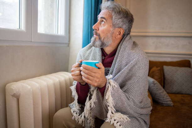 istock Senior man feel cold in home with no heating 1453523701