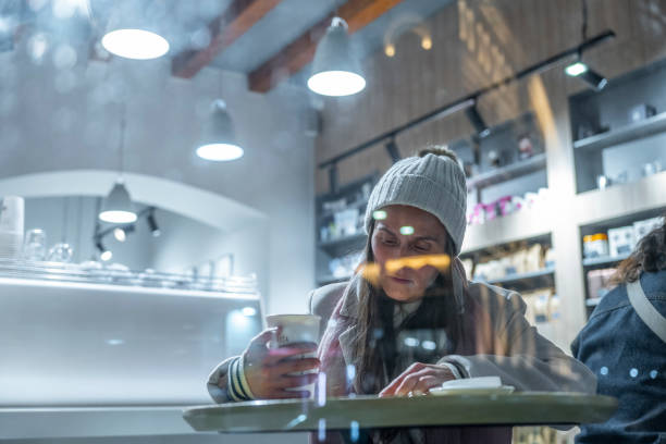 istock Woman in a coffee shop at night. 1453523788