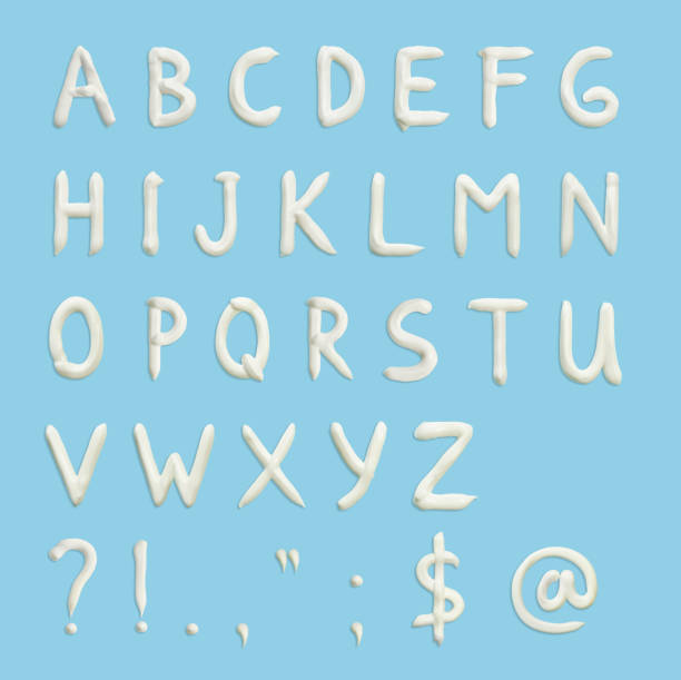 青の背景に英語のアルファベットと句読点の文字、および白の絞りクリームの形のさまざまな記号。