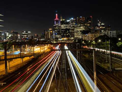 Train light trails going into Flinders Street Station with Melbourne skyline in the background