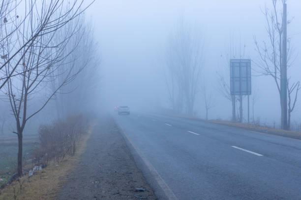 istock Thick fog in swat valley with low traffic 1453541048