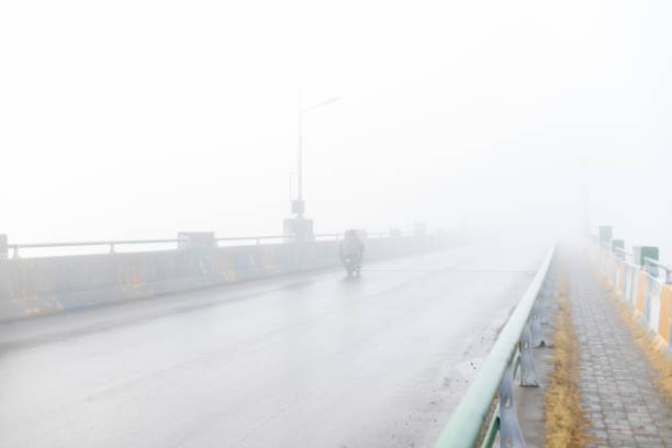istock Motorcycles in dense fog crossing the bridge with low visibility 1453542644