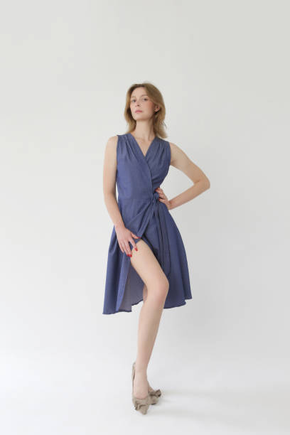 serie of studio photos of young female model in cotton denim wrap sleeveless dress. - dressmakers model fotos imagens e fotografias de stock